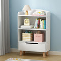 White bookshelf with books, toys, and decorative items against a blue wall.