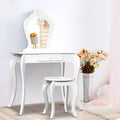 White vanity table with mirror, stool, and decorative items on a light wooden floor.