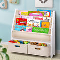 Children's bookshelf with books and toys against a light blue wall.
