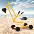 Yellow sand sculpture tool on a sandy beach with ocean in the background