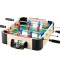 Tabletop foosball game with red and blue player figures on a white background